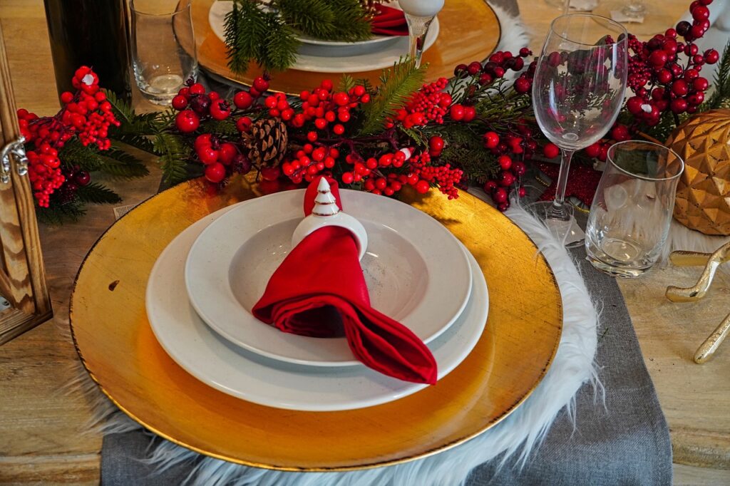 Unleash a symphony of flavors this Christmas: A decadent place setting adorned with ruby cranberries, gleaming silverware, and rich colors whispers of a luxurious Christmas feast.